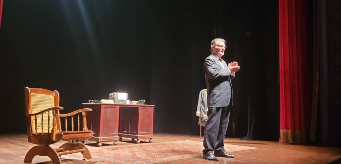 Na foto, Giuseppe Oristanio revive Guimarães Rosa no palco do Teatro Dulcina em foto de Alvaro Tallarico. Ele usa terno e bate palmas.