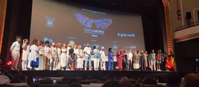 No palco do Odeon, a Equipe de Resistência Negra. Ao fundo, a tela de cinema com o logo do Festival do Rio.