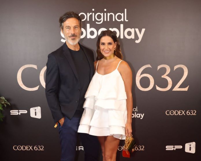 Foto mostra o ator Paulo Pires de blazer preto e a atriz Deborah Secco de vestido branco, no lançamento da série Codex 632