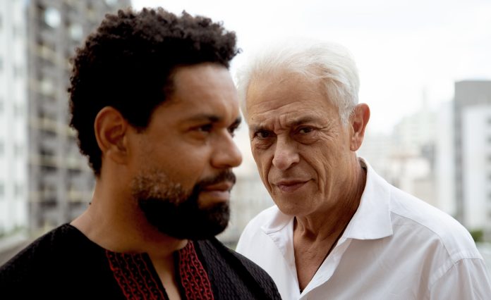 Crítica de Entre Franciscos. Na foto, os rostos de César Mello, negro e de barba, e Paulo Gorgulho, branco e grisalho.