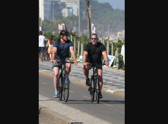 Hugh Jackman pedala de bike pela orla carioca