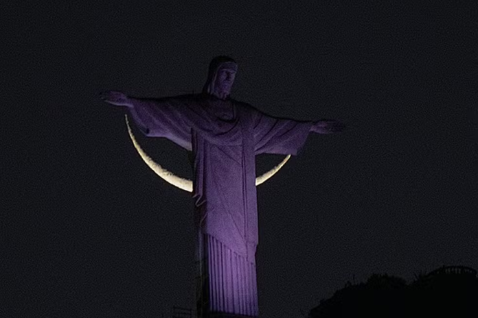 Lua 'abraça' o Cristo. Reprodução: Ari Kaye.